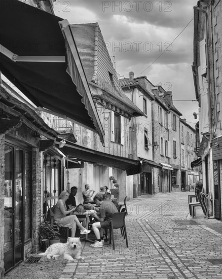 Group of people at outdoor café on quaint street, Belves, Dordogne, France