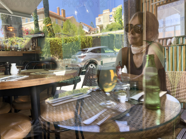 Woman having lunch in café, Monte Estoril, Cascais, Portugal