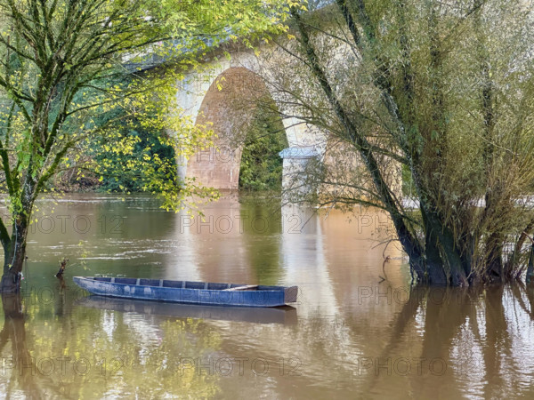 Blue rowboat on river, Dordogne, France