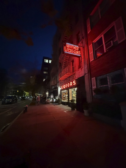 Liquor store and street scene at night, Chelsea, New York City, New York, USA