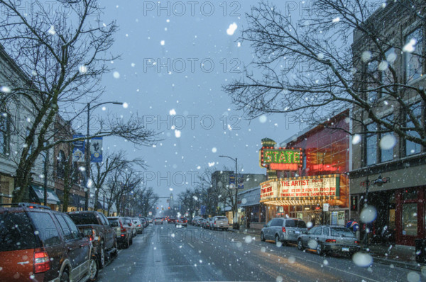 Snowy street scene with illuminated movie theater marquee, Traverse City, Michigan, USA