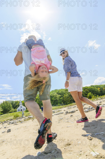 Rear view of parents with young daughter at beach