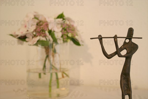 France, Normandie, Manche, chambre d'hotes : montchaton, carrouge, statuette joueur de flute et bouquet de fleurs,