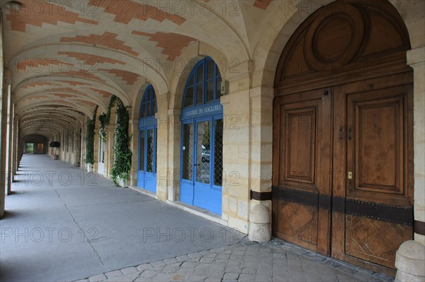 France, ile de france, paris 4e arrondissement, marais, place des vosges, arcades au niveau du numero 9, porte en bois.
Date : 2011-2012