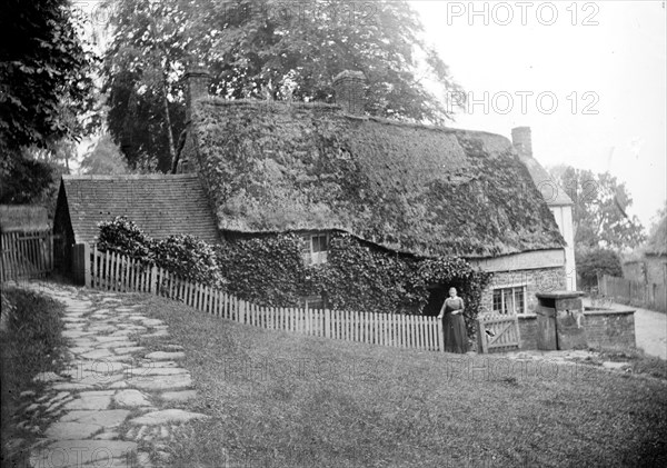 Postmistress in front of the post office at Upper Boddington, Northamptonshire, c1873-c1923