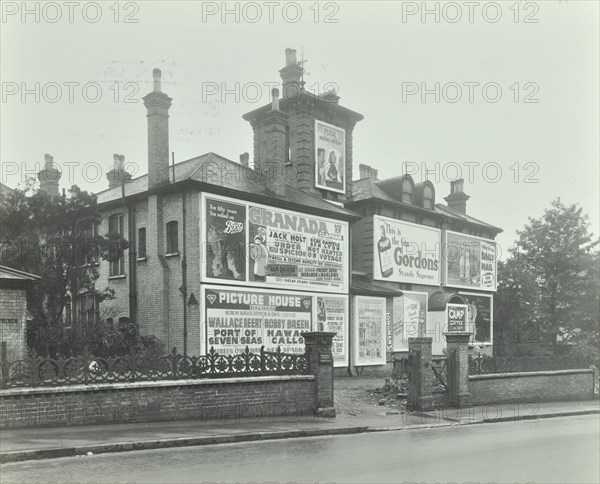 Advertising hoardings on the wall of a building, Wandsworth, London, 1938. Artist: Unknown.