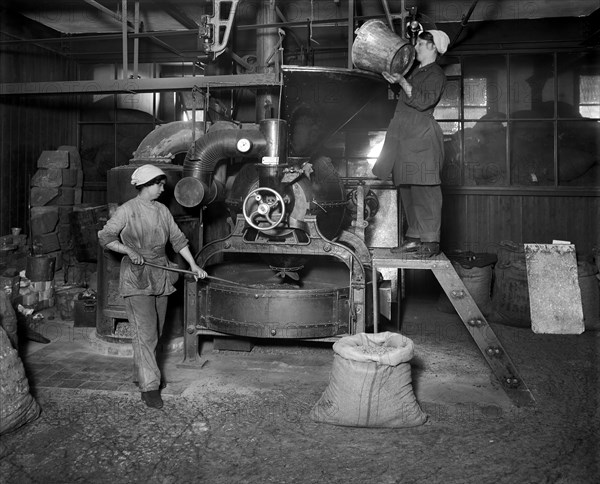 Two women filling Sirocco roaster with coffee beans, J Lyons and Co, London, July 1918