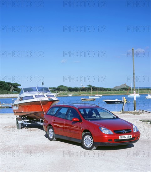 2002 Citroen C5 hdi towing a boat by harbour. Artist: Unknown.