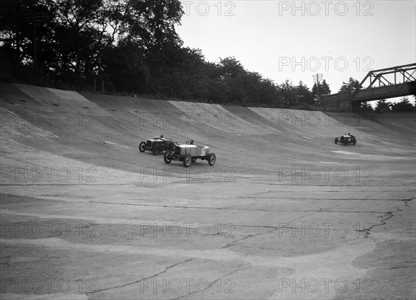 Alvis 17 and Austin 747 cc racing on the banking at Brooklands. Artist: Bill Brunell.