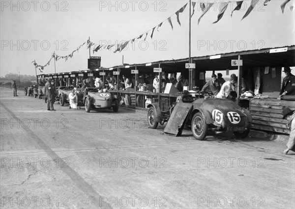 Talbot 105 and Lea-Francis cars in the pits at the JCC Double Twelve race, Brooklands, 8/9 May 1931. Artist: Bill Brunell.