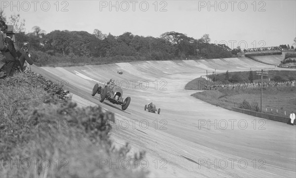 Sir Henry Birkin's Bentley leading Earl Howe's Bugatti Type 54, BARC meeting, Brooklands, May 1932. Artist: Bill Brunell.