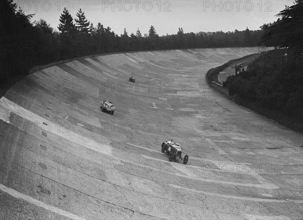 Frazer-Nash and Frazer-Nash BMW racing on the banking at Brooklands, 1938 or 1939. Artist: Bill Brunell.