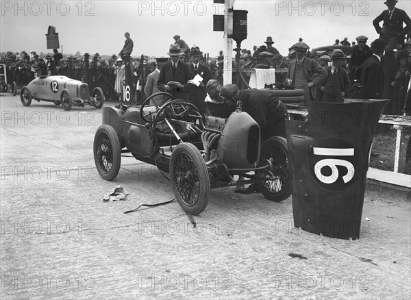 Leon Cushman working on his Bugatti Brescia at the JCC 200 Mile Race, Brooklands, Surrey, 1922. Artist: Bill Brunell.