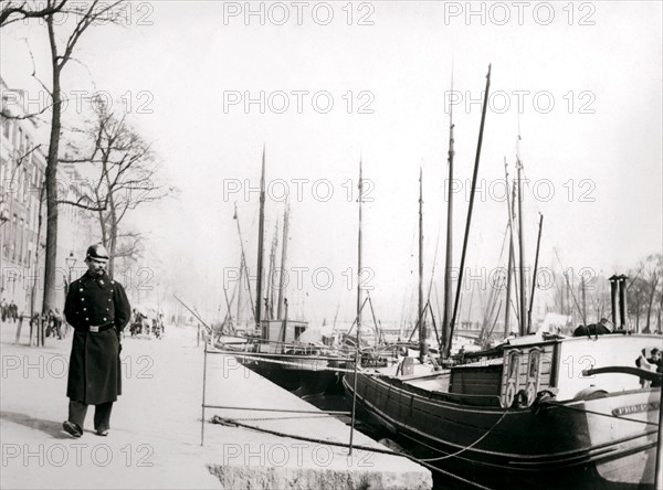 Policeman by a canal, Rotterdam, 1898.Artist: James Batkin