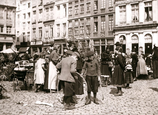 Boys with hoops at a market, Rotterdam, 1898.Artist: James Batkin