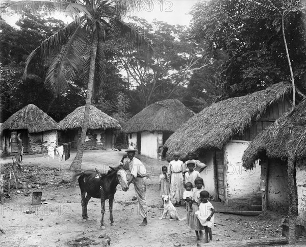 Family outside their home, Coolie Street, Kingston, Jamaica, 1931. Artist: Unknown