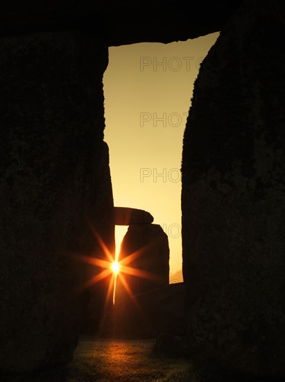 View of Stonehenge, showing the sun's rays glinting through the opening in a trilithon, 2012. Creator: James O Davies.