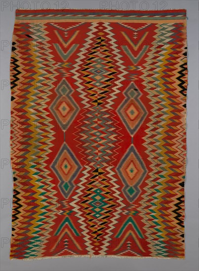 Germantown Eyedazzler Rug, Arizona, c. 1800/90. In 1864 the U.S. government forcefully resettled the Navajo in the Bosque Redondo reservation. The brightly coloured commercial yarns they received as part of their government annuities prompted a cultural and artistic transformation in their weaving, with bold designs incorporating serrated diamonds, chevrons, zigzags and interlocking lines.