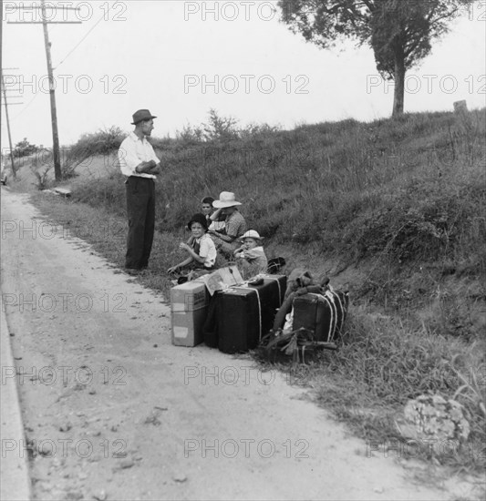 A hitchhiking family waiting along the highway in Macon, Georgia, 1937. Creator: Dorothea Lange.