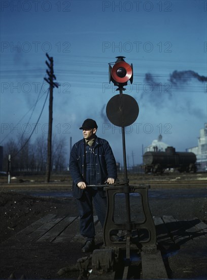 Daniel Senise throwing a switch while at work in an Indiana Harbor Belt Line railroad yard, 1943. Creator: Jack Delano.