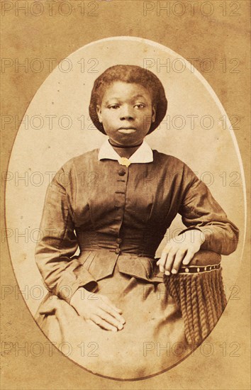 Studio portrait of young woman with thin ribbon around neck, (1880-1889?). Creator: A. T. Hunt.