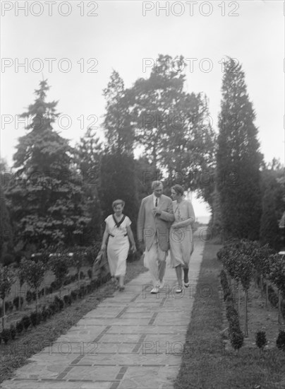 Edge, Charles N., walking with Margaret Edge and another woman in his garden, 1932 or 1933. Creator: Arnold Genthe.