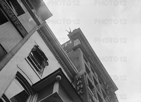 J. Reynolds, Performing Acrobatic And Balancing Acts On High Cornice Above 9th Street, N.W., 1917. Creator: Harris & Ewing.