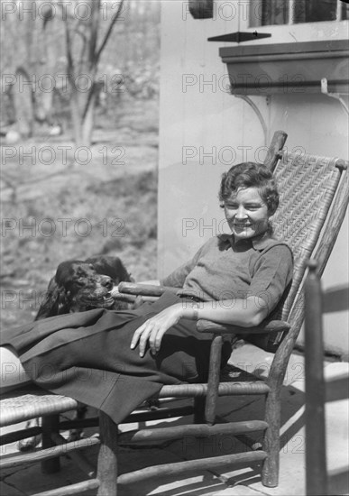 DeLamar, Alice, Miss, with dog, seated outdoors, between 1927 and 1942. Creator: Arnold Genthe.