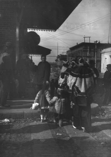 Women and children crossing a street, Chinatown, San Francisco, between 1896 and 1906. Creator: Arnold Genthe.