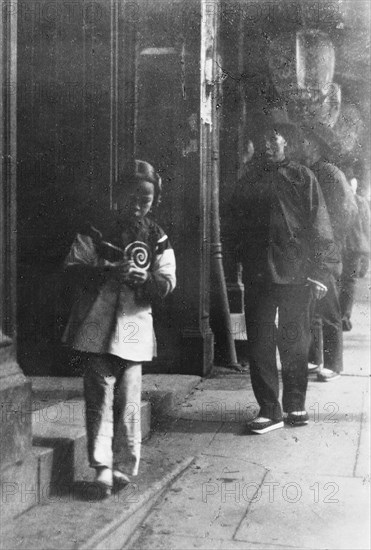 Young girl walking down a street, Chinatown, San Francisco, between 1896 and 1906. Creator: Arnold Genthe.