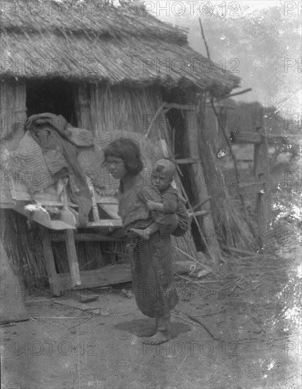 Ainu child carrying a baby on back, 1908. Creator: Arnold Genthe.