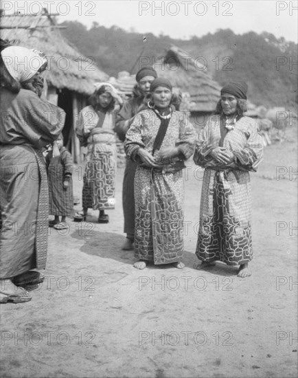 Ainu woman outside in the village lane, 1908. Creator: Arnold Genthe.