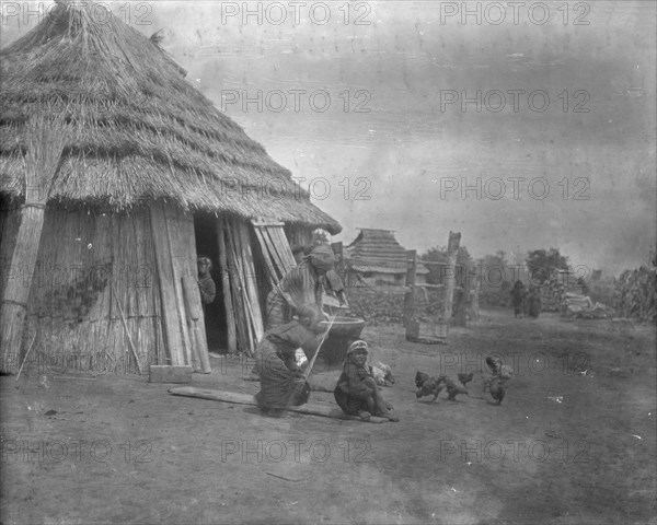 Group of Ainu outside a hut, 1908. Creator: Arnold Genthe.