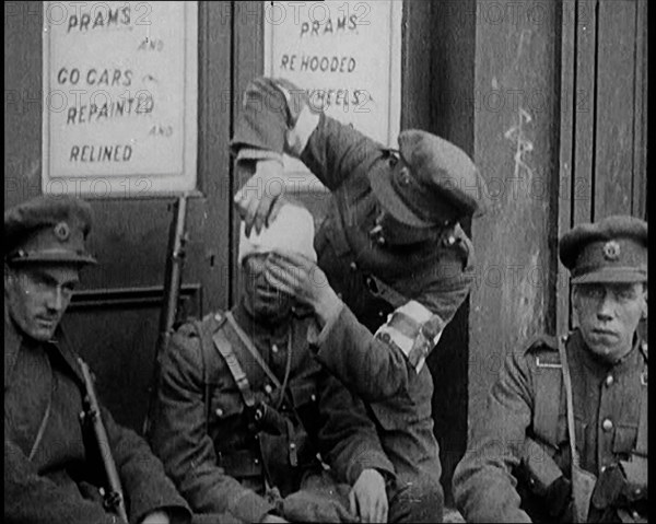 Irish Soldiers Sitting in the Street and Tending to Their Injuries from Fighting in Dublin, 1922. Creator: British Pathe Ltd.