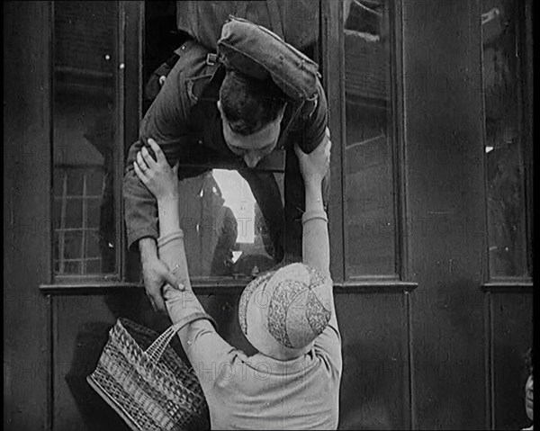 Male Soldier Kissing Female Civilian from the Window of a Train, 1929. Creator: British Pathe Ltd.