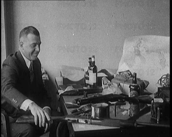 Male Detective Showing off Smugglers' Captured Guns, 1929.  Creator: British Pathe Ltd.