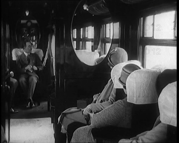 Female Civilian Wearing a Dress and Hat Modelling in Front of a Small Audience Inside a..., 1920. Creator: British Pathe Ltd.