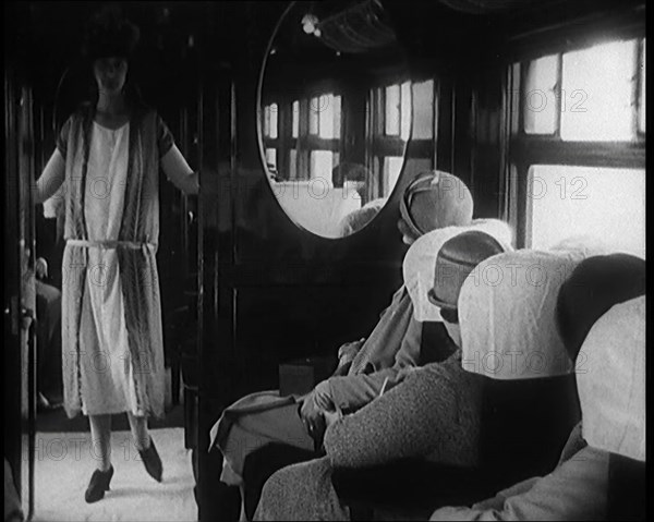 Female Civilian Wearing a Dress and Hat Modelling in Front of a Small Audience Inside a..., 1920. Creator: British Pathe Ltd.