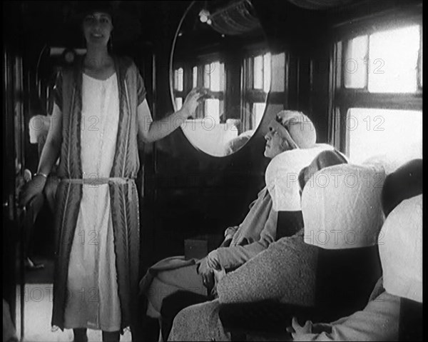 Female Civilian Wearing a Dress and Hat Modelling in Front of a Small Audience Inside a..., 1920. Creator: British Pathe Ltd.