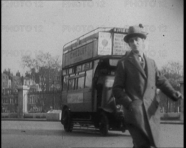 Male Civilian Crossing the Street in Front of Heavy Cars and Buses Traffic, 1920. Creator: British Pathe Ltd.