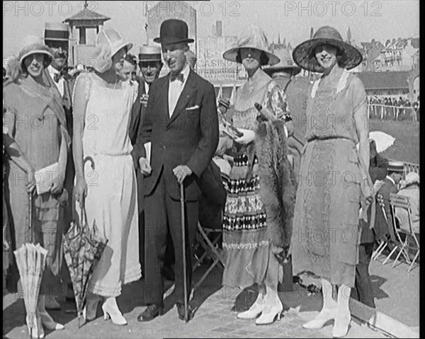 Civilians Wearing Smart Outfits and Hats Posing for the Camera During a Horse Race, 1920. Creator: British Pathe Ltd.