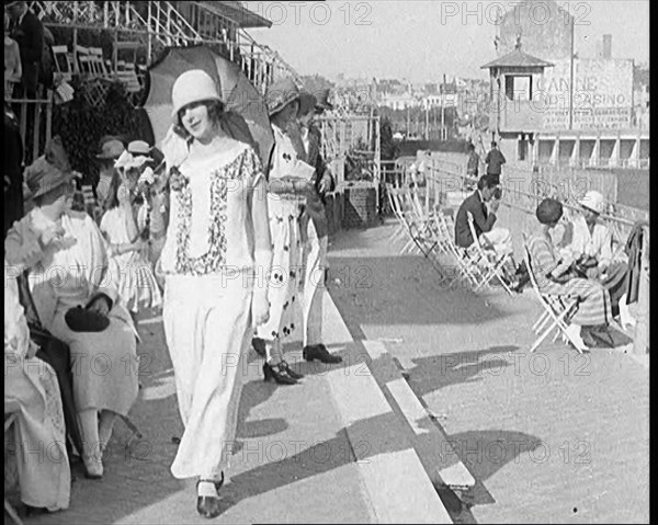 Female Civilian Wearing Smart outfit and Hat Holding a Parasol Walking Towards the Camera..., 1920. Creator: British Pathe Ltd.