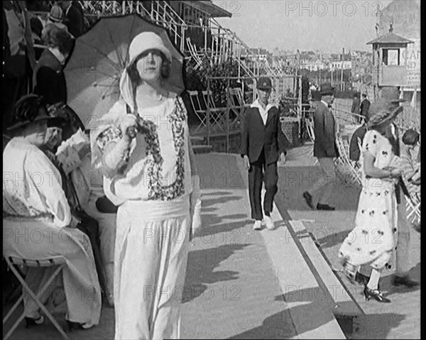 Female Civilian Wearing Smart outfit and Hat Holding a Parasol Walking Towards the Camera..., 1920. Creator: British Pathe Ltd.