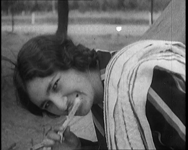 Female Civilian with Dark Hair Brushing Her Teeth Outdoors, 1920. Creator: British Pathe Ltd.