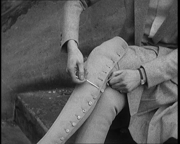 Female Civilian Using a Button Hook to Button up Her Leather Boots, 1920. Creator: British Pathe Ltd.