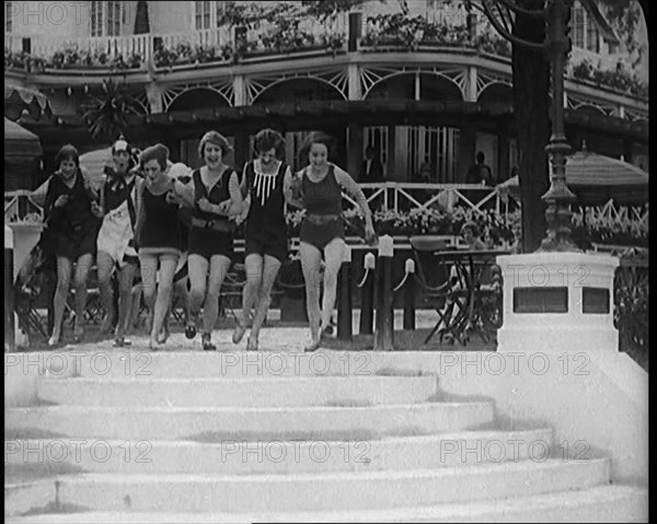 A Group of Young Female Civilians Running down Some Steps Wearing Swimsuits, 1920. Creator: British Pathe Ltd.