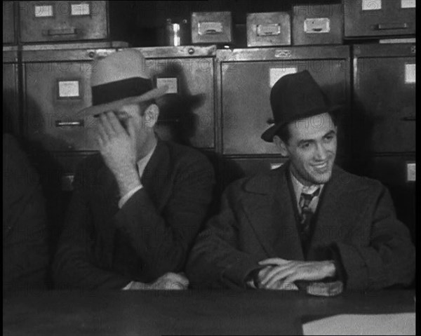 Male American Civilians Wearing Hats Sitting at a Desk, 1930. Creator: British Pathe Ltd.