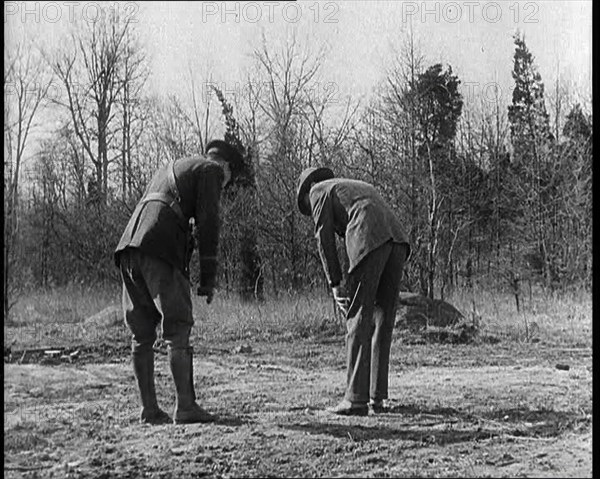 Male American Police Officers Investigating Footprints Outside American Aviator Charles..., 1930s. Creator: British Pathe Ltd.