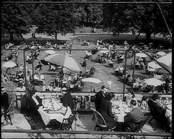 People Sitting at Tables on a Balcony While Another Group of People Sit Below, 1933. Creator: British Pathe Ltd.