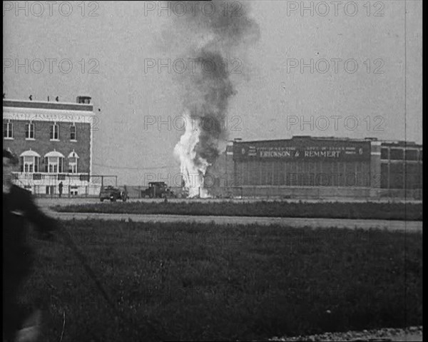 Plume of Flame Emitting from the ‘Bellanca’ Crash as People Attend to Wreckage, 1933. Creator: British Pathe Ltd.